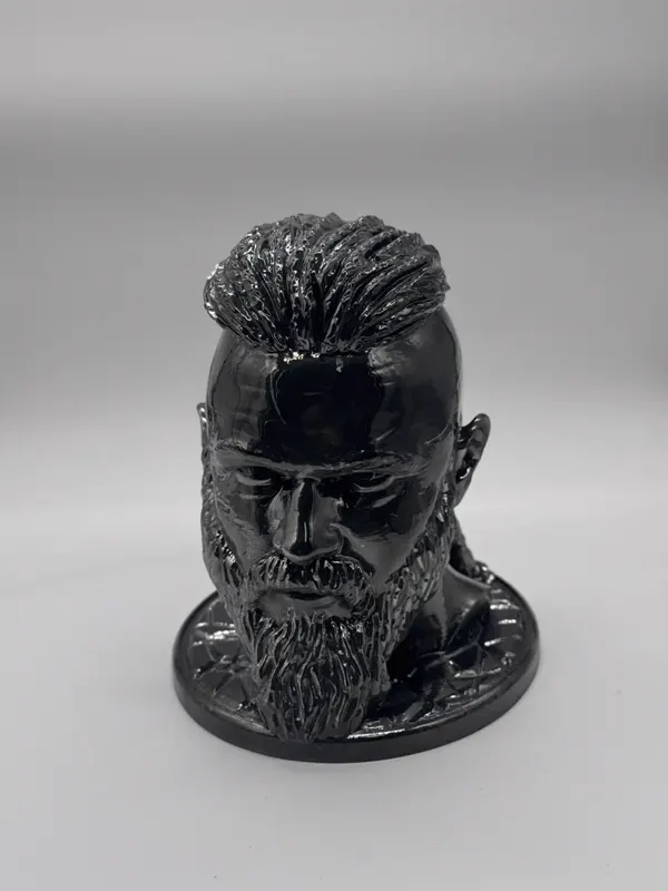 Buste d'un personnage barbu imprimé en 3D, finition noir brillant, posé sur un socle rond
