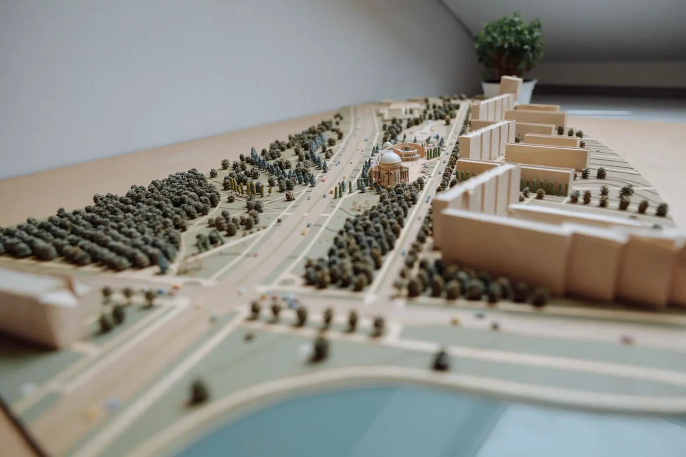 Maquette d'urbanisme vue de près : des immeubles clairs, des rues et des rangées de petits arbres à l'échelle